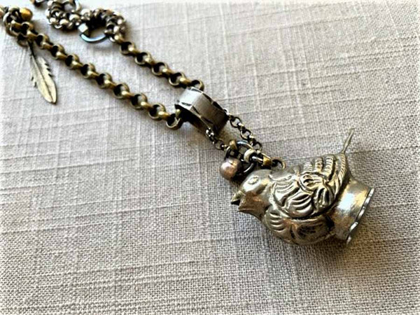 closeup of antique tin salt shaker (bird) pendant on chain mix