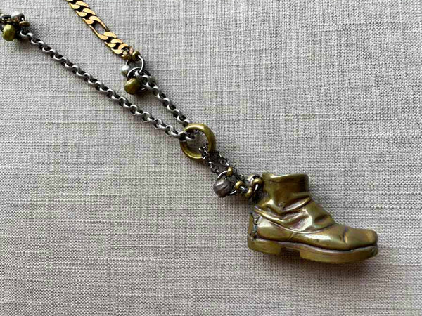 closeup of antique bronze match safe (boot) pendant on chain mix