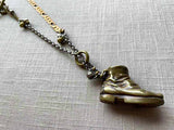 closeup of antique bronze match safe (boot) pendant on chain mix