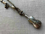 closeup of antique sterling silver cello pendant on chain mix