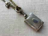 closeup of antique sterling silver match safe (book) pendant on chain mix