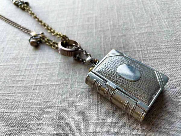 closeup of antique sterling silver match safe (book) pendant on chain mix