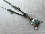 top view of antique sterling silver frog pendant on chain mix