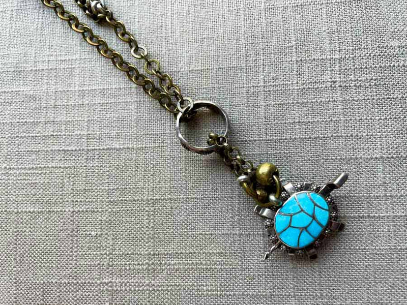 closeup of antique sterling silver turtle pendant on chain mix 