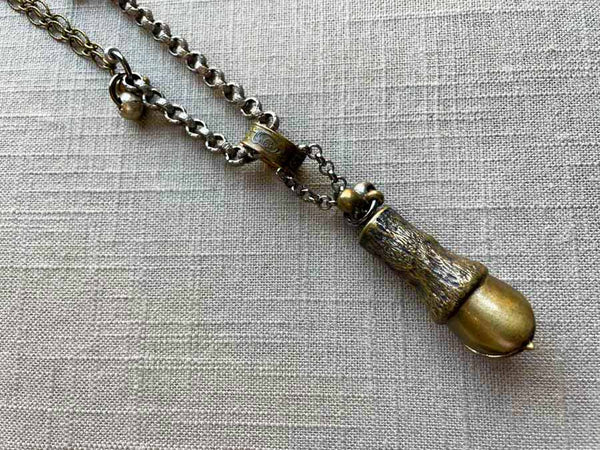 closeup of antique bronze match safe (horse hoof) pendant on chain mix