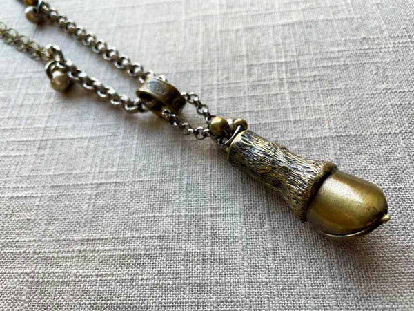 closeup of antique bronze match safe (horse hoof) pendant on chain mix