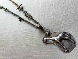 top view of antique sterling silver giraffe candy mold pendant on chain mix