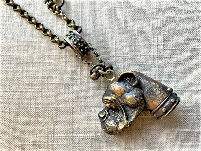 closeup of antique bronze match safe (bulldog) pendant on chain mix