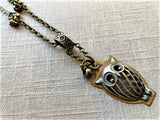 closeup of antique owl pendant  on chain mix