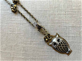 closeup of antique owl pendant on chain mix