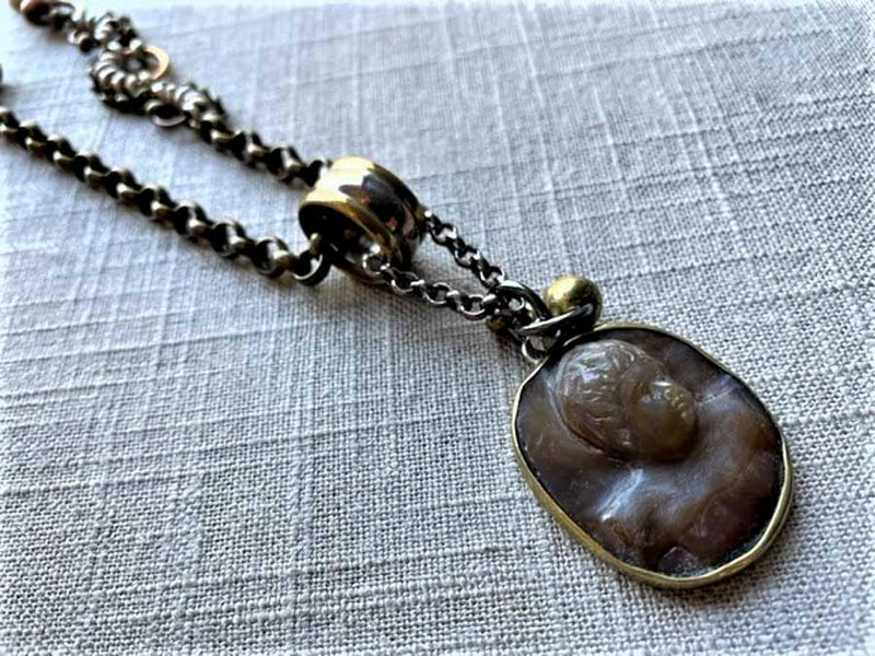 closeup of antique carved cameo pendant (eros) on chain mix