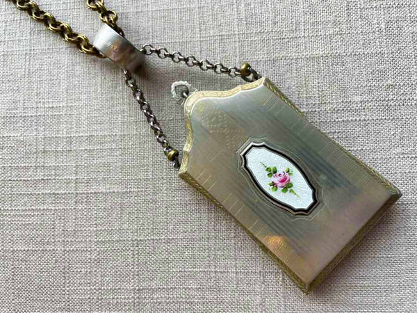 closeup of antique sterling silver compact pendant on chain mix