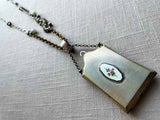 top view of antique sterling silver compact pendant on chain mix