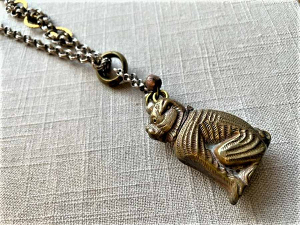 closeup of antique bronze match safe pendant (bulldog) on chain mix