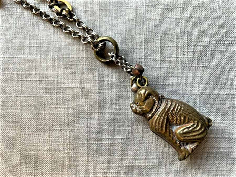 closeup of antique bronze match safe pendant (bulldog) on chain mix