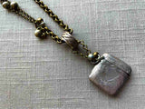 closeup of antique sterling silver match safe pendant on chain mix