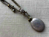 closeup of antique sterling silver locket pendant on chain mix