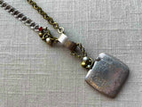 closeup of antique sterling silver match safe pendant on chain mix