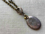 closeup of antique sterling silver locket pendant on chain mix