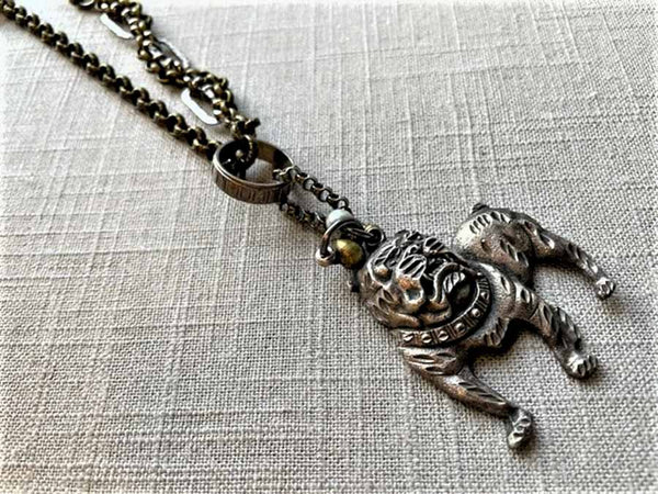 closeup of antique sterling silver bulldog pendant on chain mix