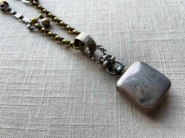 closeup of antique sterling silver change holder pendant on chain mix