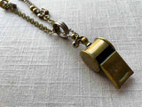 closeup of antique bronze whistle pendant on chain mix