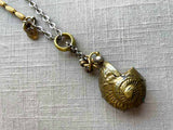 closeup of antique bronze match safe (seashell) pendant on chain mix