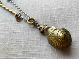 closeup of antique bronze match safe (seashell) pendant on chain mix