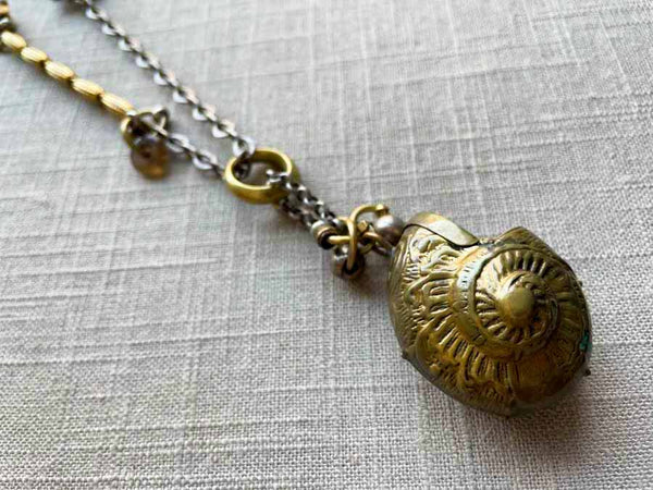 closeup of antique bronze match safe (seashell) pendant on chain mix