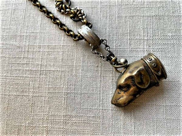 closeup of antique bronze match safe pendant on chain mix