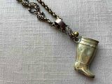 closeup of antique silver-plate match safe (boot) pendant on chain mix