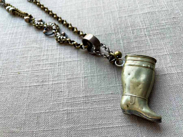 closeup of antique silver-plate match safe (boot) pendant on chain mix