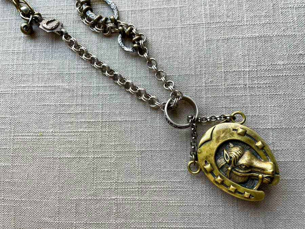 closeup of antique bronze match safe pendant on chain mix