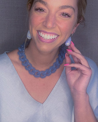 model wearing resin earrings in matte blue