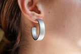 Model wearing resin earrings in matte silver