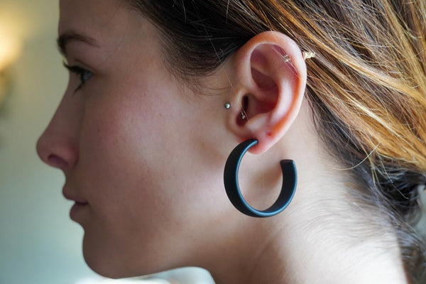 Model wearing resin earrings in matte black