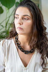 model wearing resin necklace in brown and grey