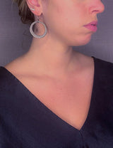 model wearing organic-shaped silver earrings