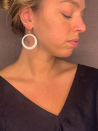 model wearing organic-shaped silver earrings