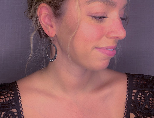 model wearing organic-shaped silver earrings