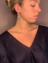 model wearing organic-shaped silver earrings