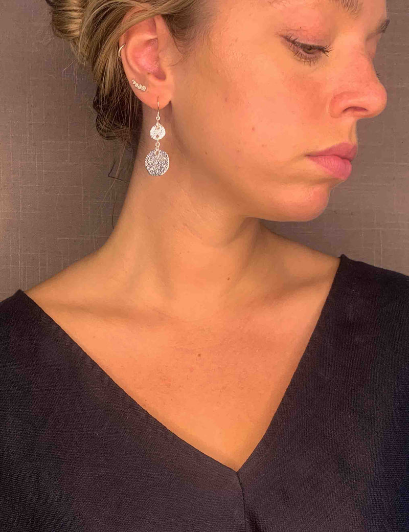 model wearing organic-shaped silver earrings