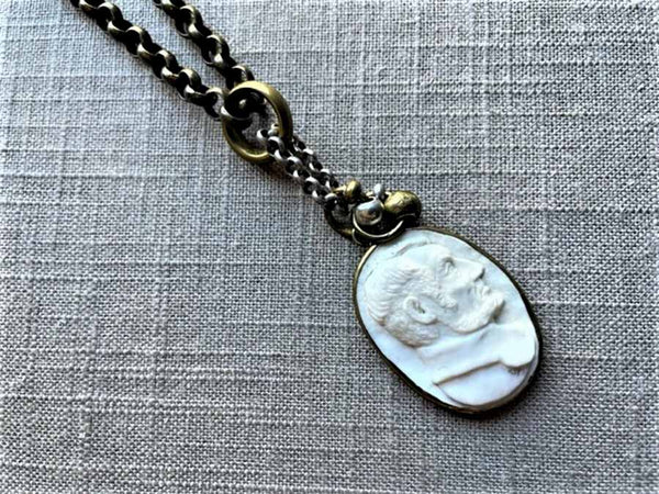 closeup of antique carved Lincoln cameo pendant on chain mix