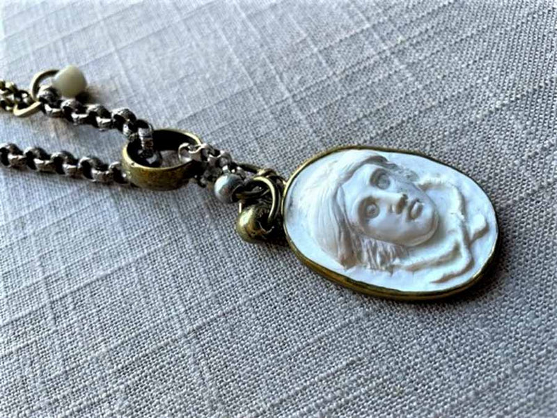 closeup of antique carved Medusa cameo pendant on chain mix