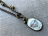 closeup  of antique carved Medusa cameo pendant on chain mix