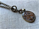 closeup of antique carved knight's face shield cameo pendant on chain mix