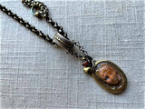 closeup of antique carved Medusa cameo pendant on chain mix