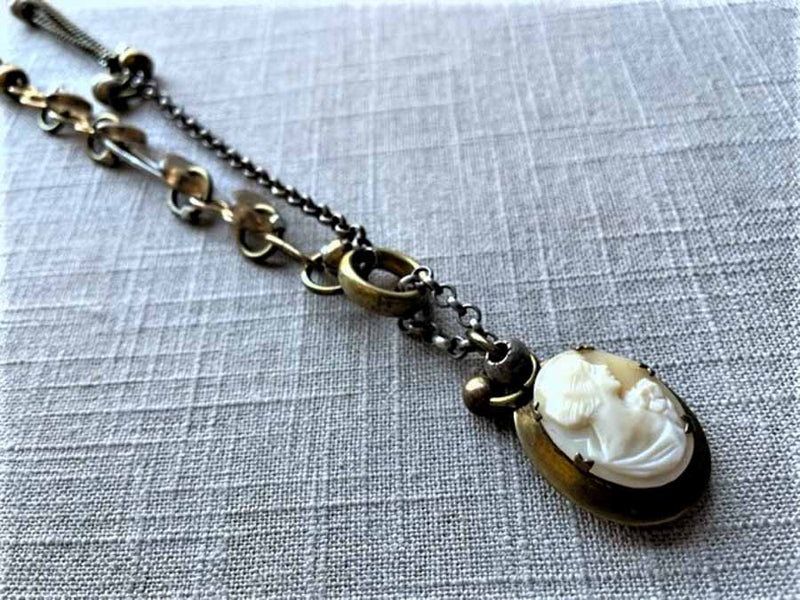 side view  of antique carved cameo locket pendant on chain mix