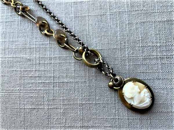 closeup of antique carved cameo locket pendant on chain mix