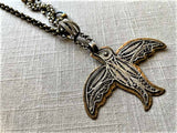 closeup  of antique filigree bird pendant on chain mix